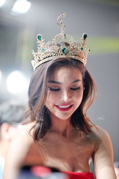 a woman wearing a tiara looking at her cell phone