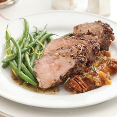 a white plate topped with meat and green beans