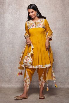 Mustard kalidar kurta with floral embroidered yoke and sequin detailing. Paired with dhoti and scallop hem dupatta.
Component: 3
Printed, Embroidered
Neckline: Round
Sleeve Length: Three Quarter
Fabric: Mulmul, Kota Doria
Color: Yellow
Drawstring with tassels at the side
Front potli placket
Pearl detailing at the sleeves
Printed detailing on the dhoti
Tassels on the dupatta
Note: Potli shown in the image is not for sale - Aza Fashions Kurti With Dhoti Salwar, Plazo Designs, Long Kurti Patterns, Bride Fashion Illustration, Boutique Suits, Kurti Patterns, Saree Poses, Dhoti Pants, Dress Design Patterns