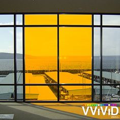 a large window that is open to the water and some boats are in the background