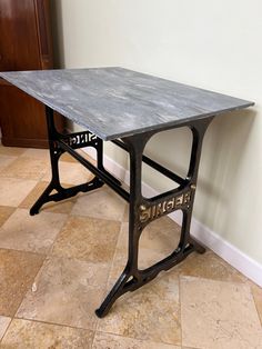 a metal table sitting on top of a tiled floor next to a wall and door