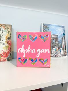 a pink sign that says aloha gam on it next to some pictures