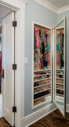 an open closet filled with lots of jewelry and bracelets in it's doors