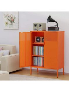 an orange cabinet with books and speakers in it