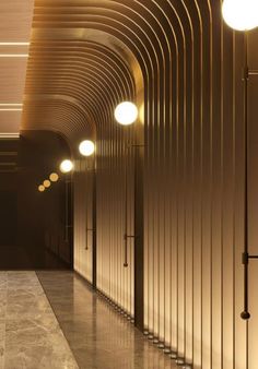 an empty hallway with several lights on either side of the wall and in between them is a marble floor