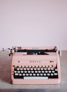 an old pink royal typewriter sitting on a table with the word royal written on it