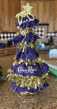 a purple and gold christmas tree sitting on top of a counter