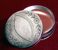 a silver plate with a red background and gold border around the edge is shown in front of an ornate frame