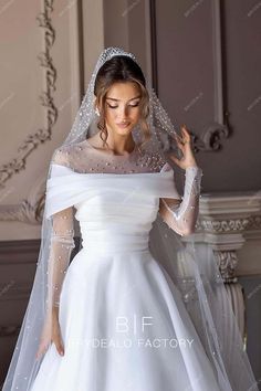 a woman in a white wedding dress with a veil on her head and hands behind her back