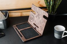 a wooden case sitting on top of a table next to a cup