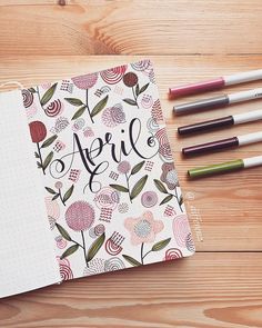 an open notebook with the word april written on it next to markers and pencils