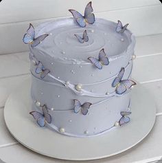 there is a white cake with blue butterflies on it