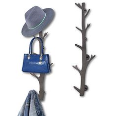 the coat rack has two hats on it and is next to a blue handbag