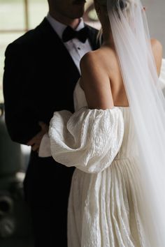 the bride and groom are standing close together