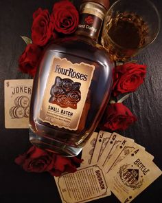 a bottle of liquor sitting on top of a table next to cards