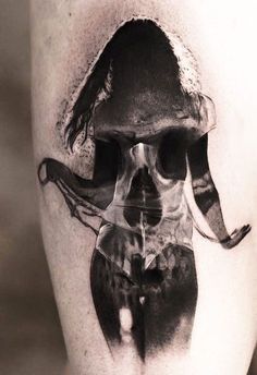 a black and white photo of a man's leg with a skull on it