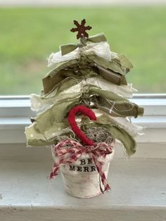 a small christmas tree sitting on top of a window sill