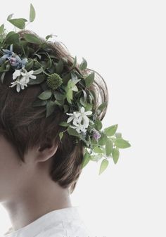 a young man with a flower crown on his head