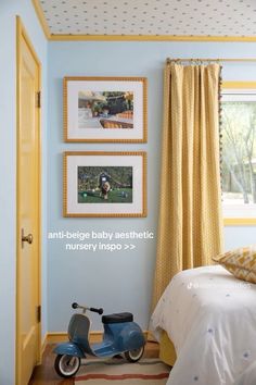 a baby's bedroom with blue walls and pictures on the wall above the bed