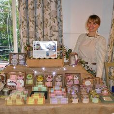 a woman standing in front of a table filled with lots of small boxes and items