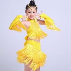 a woman in a yellow dress is posing for the camera with her hands behind her head