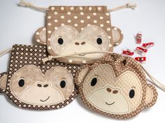 three monkey coin purses sitting next to each other