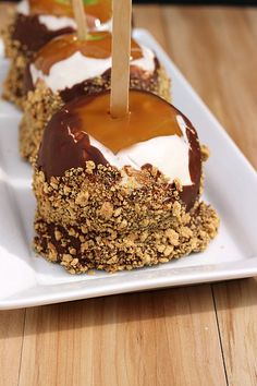 three desserts on a white plate with toothpicks sticking out of them