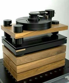 an old record player sitting on top of a wooden stand with black knobs and wood sides