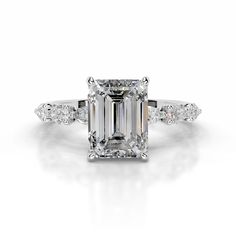 an emerald - cut diamond ring with three side stones on the band and shoulder accents