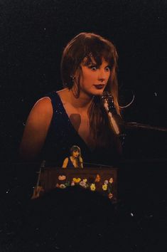 a woman with long hair holding a microphone