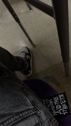 a person sitting at a table with their feet up on the chair and one foot resting on his leg