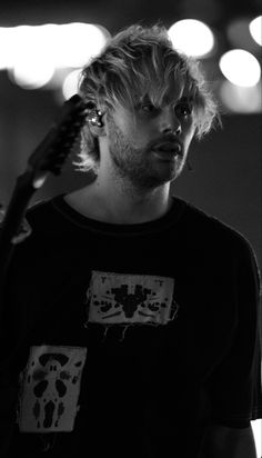 black and white photograph of a man holding a guitar