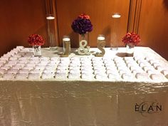 the table is covered with white paper and decorated with red, purple and orange flowers