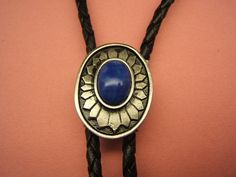 "- Southwestern Concho Bolo Tie, - Silver Plated with Antique Finish, Anti-Tarnish Added for Lasting Beauty. - Lapis or Ivory Acrylic Cabachon, - Black or Brown, 38 to 42 inch, Vinyl Leatherlike Cord with Silver Tone Cord End Tips, - \"NEW\" Tension Bolo Back, which is easier to use and helps the cord to keep from fraying. - Concho is Approx. 1 1/4 in. long by 1 in. wide, - #1084B-9, - Affordably priced! - COMES BOXED! Free Shipping* (USPS First Class Mail, US Customers) *(see my shipping policy Bohemian Silver Bolo Ties For Western-themed Events, Traditional Adjustable Jewelry For Rodeo, Silver Bohemian Bolo Ties For Western-themed Events, Silver Bohemian Bolo Tie For Western-themed Events, Bohemian Concho Jewelry For Rodeo, Elegant Concho Jewelry For Western-themed Events, Blue Concho Jewelry For Western-themed Events, Bohemian Concho Jewelry For Western-themed Events, Traditional Concho Jewelry For Western-themed Events