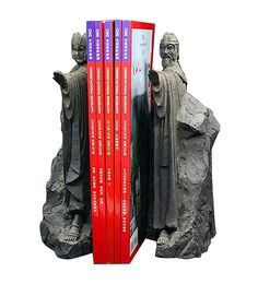 three books are stacked on top of each other in front of a book case with statues