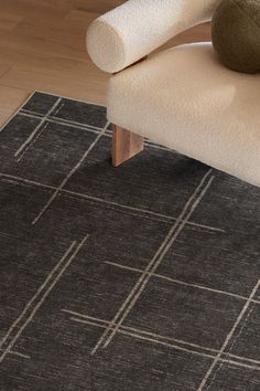 a black rug with white lines on it and a chair in the corner next to it