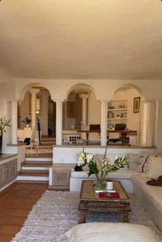 a living room filled with white furniture and lots of windows on top of it's walls