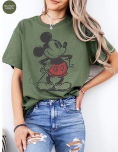 a woman wearing a green mickey mouse t - shirt with the word disney on it