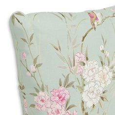 a blue pillow with pink and white flowers on the front, along with a green background