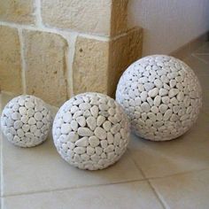 three white balls sitting on top of a tiled floor