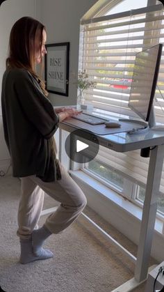 a woman standing in front of a computer desk