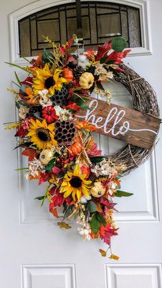 a wreath with the word hello written on it and sunflowers, leaves, and acorns