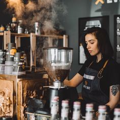 a woman standing in front of a coffee machine