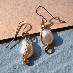 These Handmade Gold Filled Hoop Earrings Have A Subtle Asymmetrical Design And A Wire Wrap That Accentuates The Unique Shape Of Each Pearl. They Measure 1.25 Inches Long. Made With High Quality 12-14k Gold Fill With A Jeweler’s Brass Core. Elegant Gold Wire Wrapped Wrap Earrings, Gold Pearl Earrings With Ear Wire For Fine Jewelry, Elegant Gold Wire Wrapped Teardrop Earrings, Elegant Rose Gold Wrap Earrings With Ear Wire, Elegant Rose Gold Wrap Earrings, Elegant White Single Wrap Earring, Formal Wire Wrapped Drop Earrings, Formal Teardrop Wire Wrapped Earrings, Elegant Gold Wrap Earrings With Ear Wire