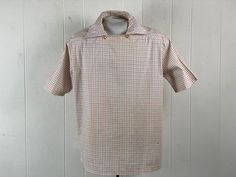 "Vintage 1950s short sleeve shirt. Made of cotton with a gray and blue windowpane plaid pattern.Pull over style with two buttons at the collar and straight hem. Missing label, about a size large. Actual measurements are   50\" at the chest   49\" at the waist   19\" shoulder seam to shoulder seam   28\" overall length  In good condition with a small spot lower front, and slightly sun faded, see picture." Plaid Collared Shirt With Placket, Collared Plaid Shirt With Placket, Plaid Collared Shirt, Retro Plaid Collared Tops, Fitted Gingham Shirt With Short Sleeves, Vintage Plaid Collared Shirt, Retro Short Sleeve Plaid Shirt, Retro Plaid Short Sleeve Shirt, Vintage Gingham Button-up Shirt