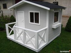 a small white house sitting on top of a lush green field