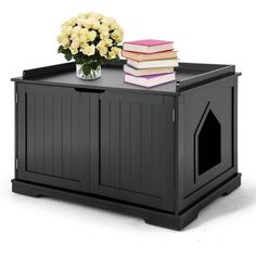 a black dog house with flowers and books on the top shelf for dogs to sit in