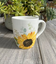 a coffee cup with sunflowers painted on it