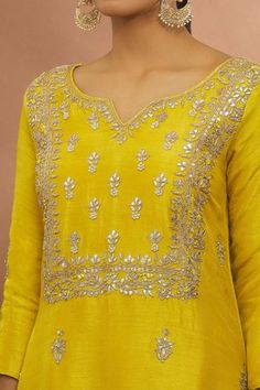 Yellow kurta with floral gota work. Paired with floral patterned sharara and tassel dupatta.
Components: 3
Pattern: Embroidered
Type Of Work: Floral
Neckline: Notched
Sleeve Type: Long
Fabric: Kurta and Sharara: Russian Chanderi, Dupatta: Organza
Color: Yellow
Other Details: 
Weight (in gms): 850
Gota work
Tassel tie-ups
Occasion: Puja - Aza Fashions Fitted Yellow Kurta With Dori Work, Yellow Sharara With Resham Embroidery And Straight Kurta, Semi-stitched Yellow Kurta With Gota Work, Yellow Sharara With Floral Embroidery And Straight Kurta, Fitted Yellow Embroidered Kurta, Tassel Dupatta, Kurta And Sharara, Chanderi Dupatta, Yellow Kurta