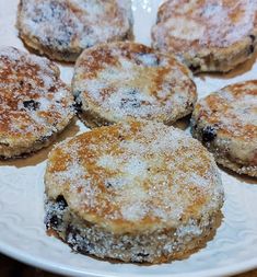 several pastries on a white plate with powdered sugar